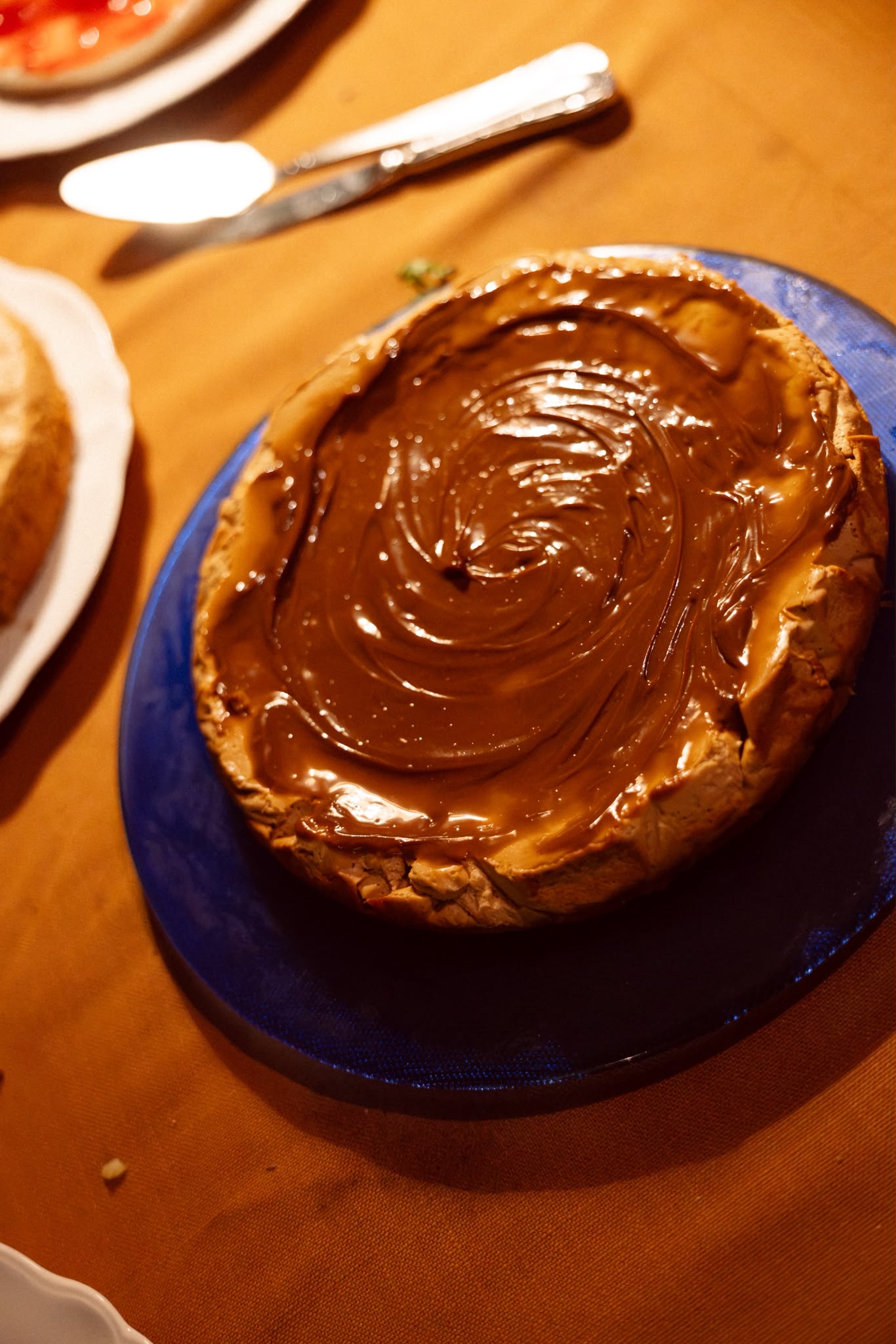 Tarta con cobertura en espiral sobre un plato azul en la mesa de postres